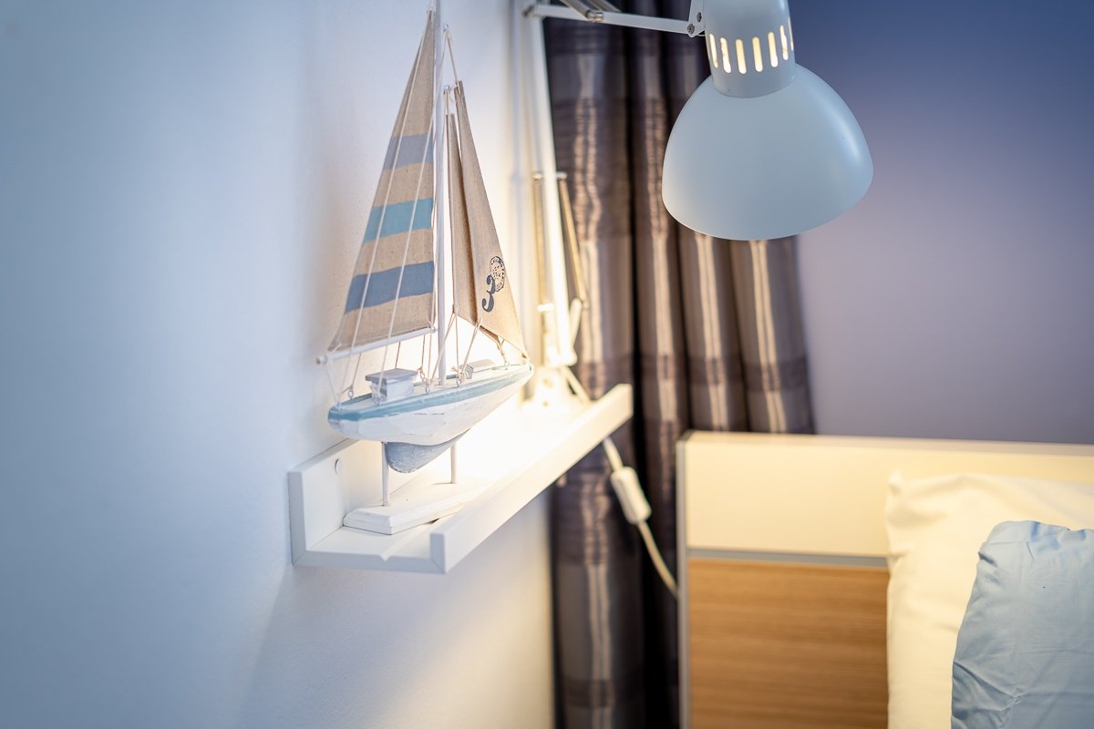 A small painted sailboat on a shelf — a quiet seaside detail inside the house